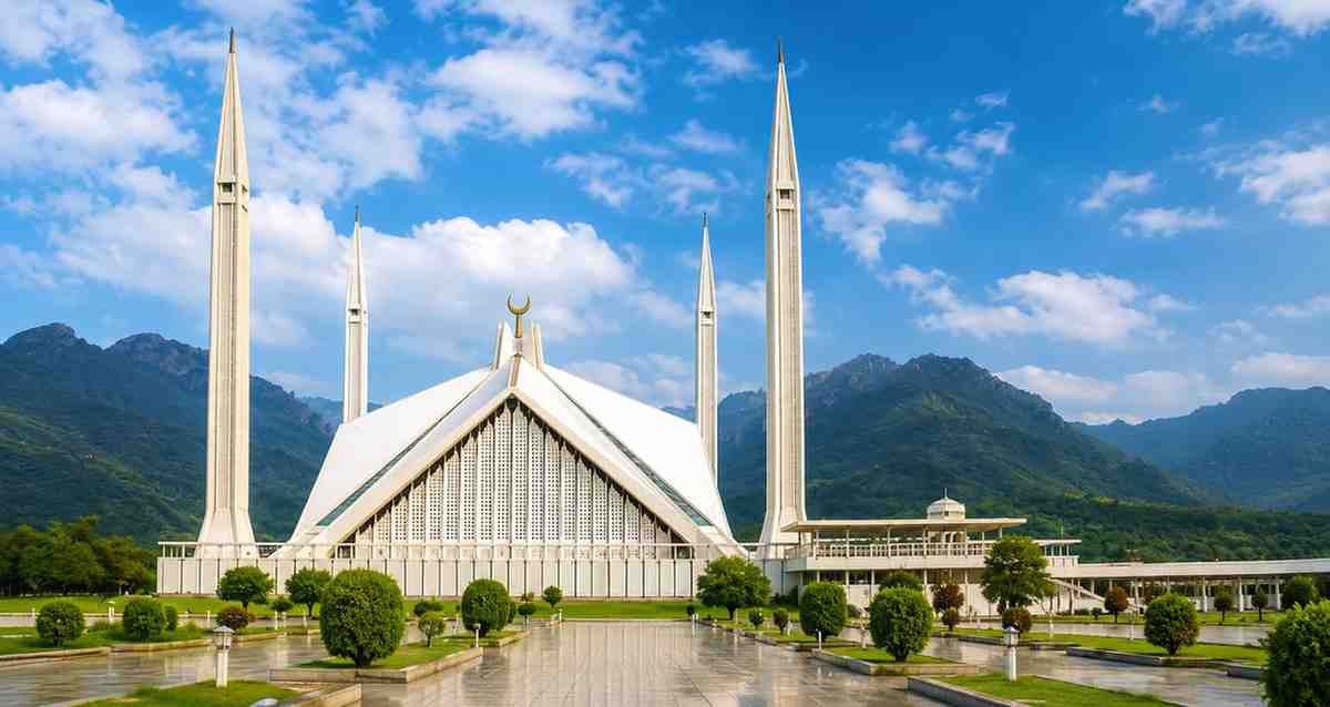 Faisal Mosque in Islamabad with mountains in the background representing Pakistan tourism and travel